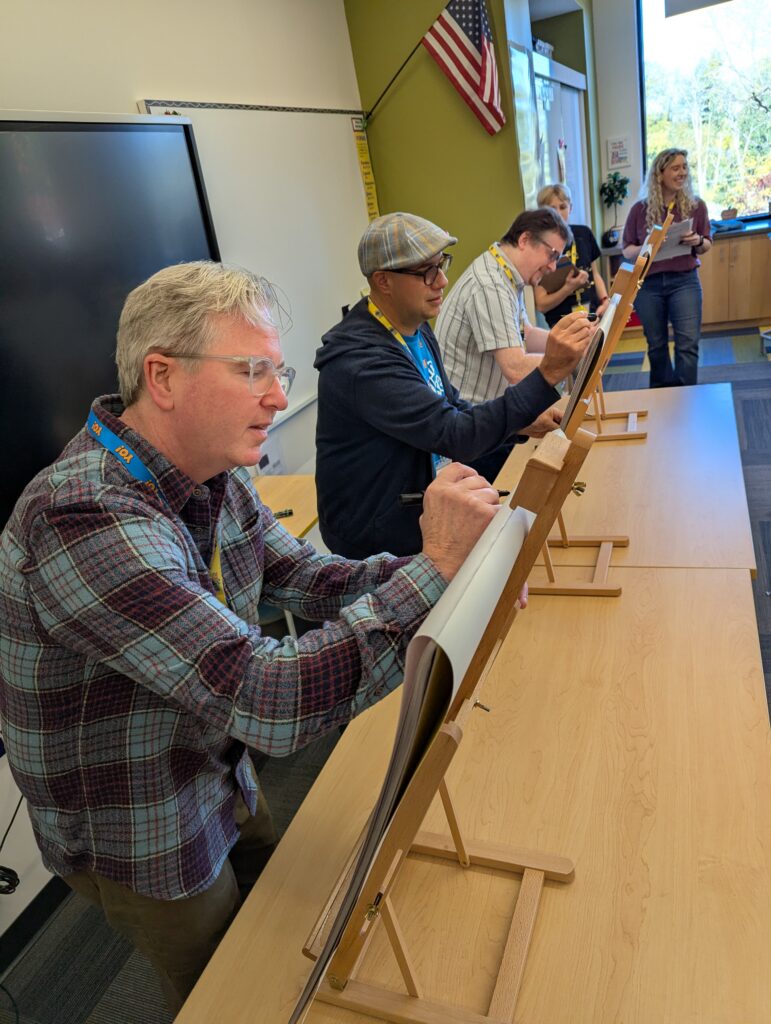 Matt Phelan, Mike Ciccatello, and John Patrick Green demonstrate how to illustrate in front of a group of children.